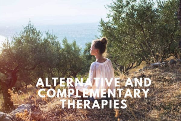 Person in a white dress sitting outdoors in nature under Alternative and Complementary Therapies text.