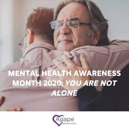 Person hugging another, text reads Mental Health Awareness Month 2020: You Are Not Alone, logo Agape Treatment Center.