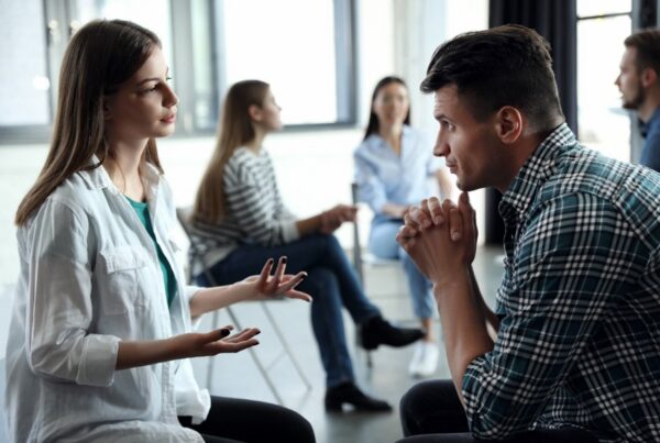 Psychotherapist working with patient in group therapy session indoors