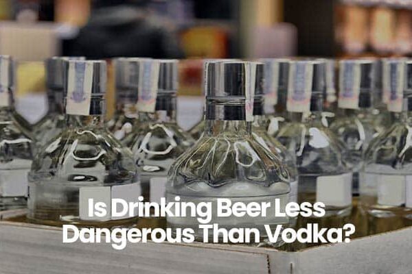 A box of clear liquor bottles with text Is Drinking Beer Less Dangerous Than Vodka? in white font.