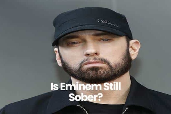Person wearing a black cap and jacket with serious expression.