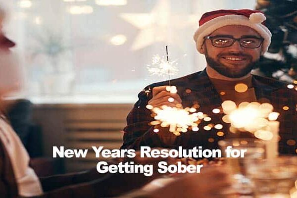 Person wearing Santa hat holding sparkler, text overlay New Years Resolution for Getting Sober.