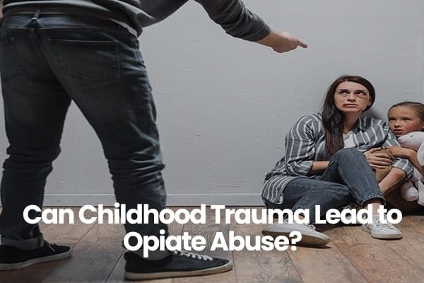 Person pointing at woman and child sitting scared in corner.