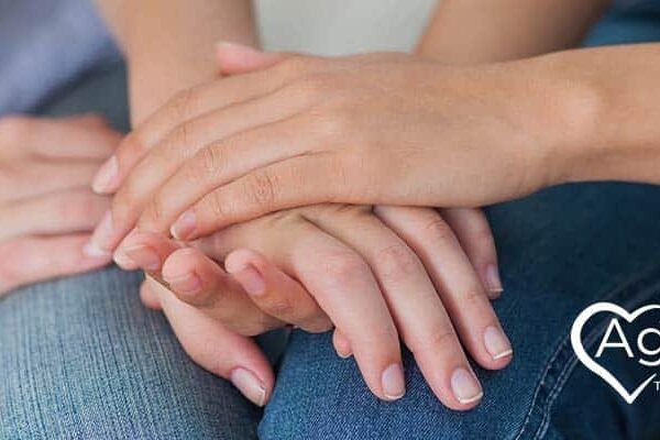 Hands offering comfort with Agape Treatment Center logo in white text and heart design.