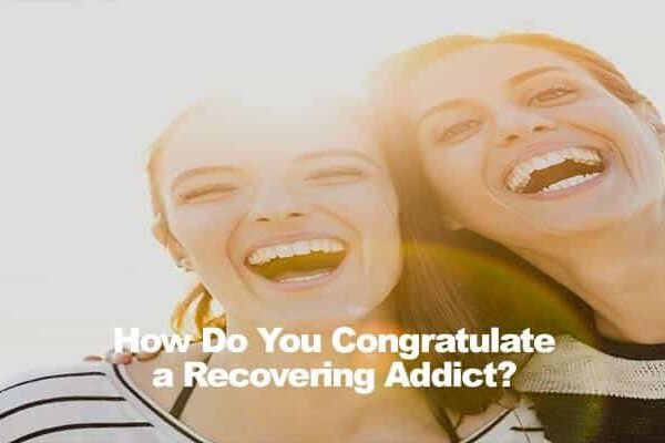 Two people smiling, one in a striped shirt, text overlay: How Do You Congratulate a Recovering Addict?