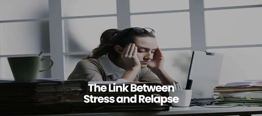 Person sitting at desk, hands on head, with books and a laptop. Text: The Link Between Stress and Relapse.