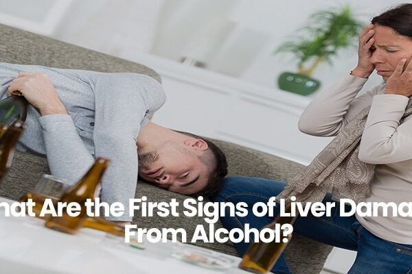 Person sleeping on couch with bottle, woman upset and covering face.