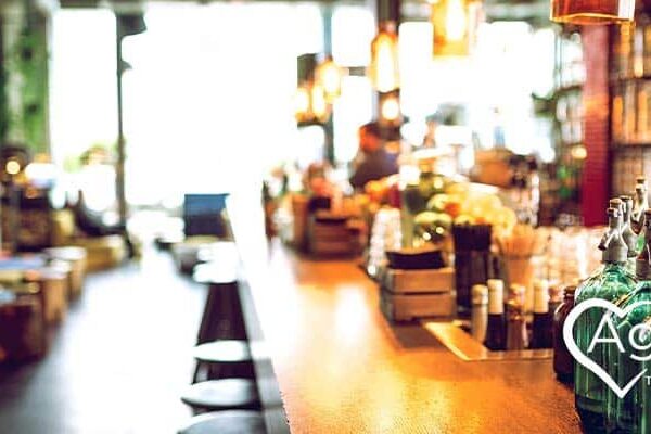 Blurred image of a bar interior with bottles, and Agape Treatment Center logo in white.