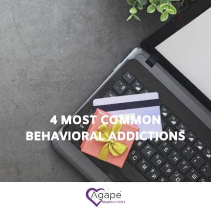 Laptop keyboard with credit cards and text 4 Most Common Behavioral Addictions.