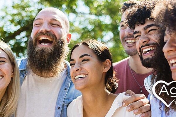 Group of people laughing together outdoors.