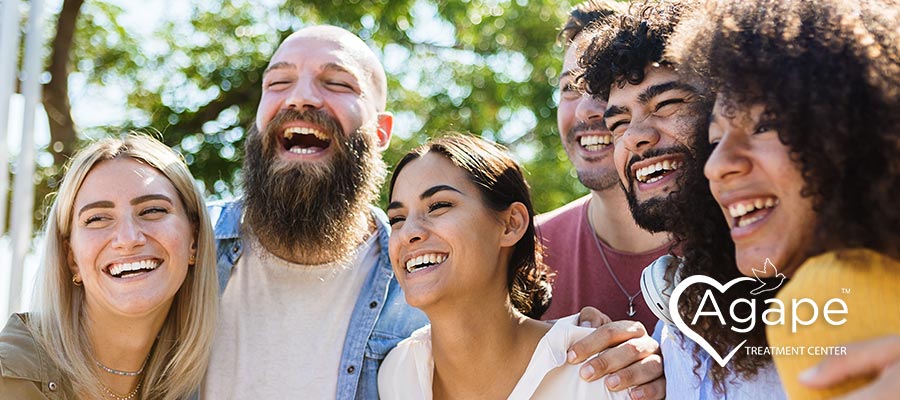 Group of people laughing together outdoors.