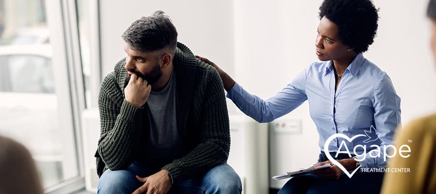woman comforting a man during group therapy session