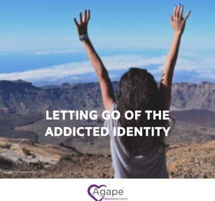 Person raising arms in front of mountain landscape with text LETTING GO OF THE ADDICTED IDENTITY.