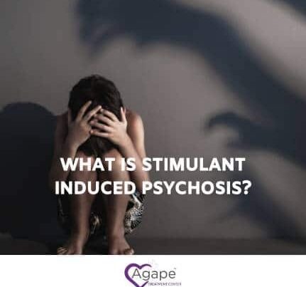 Person sitting, head in hands, with shadowy figures on wall. Text: What is stimulant induced psychosis?