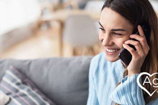 Person wearing a blue shirt, smiling on phone.