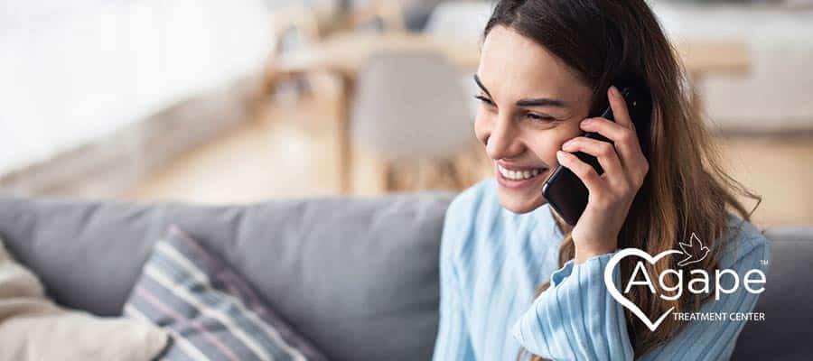 Person wearing a blue shirt, smiling on phone.