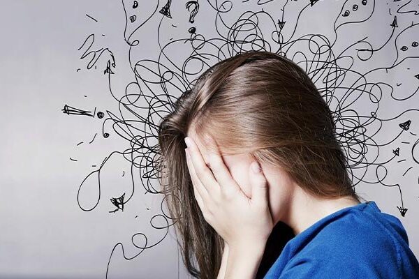 Person in blue shirt covering face with doodles around head.