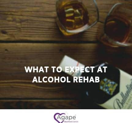 What to Expect at Alcohol Rehab text over blurred whiskey glasses and bottle on wood table, Agape logo at bottom.