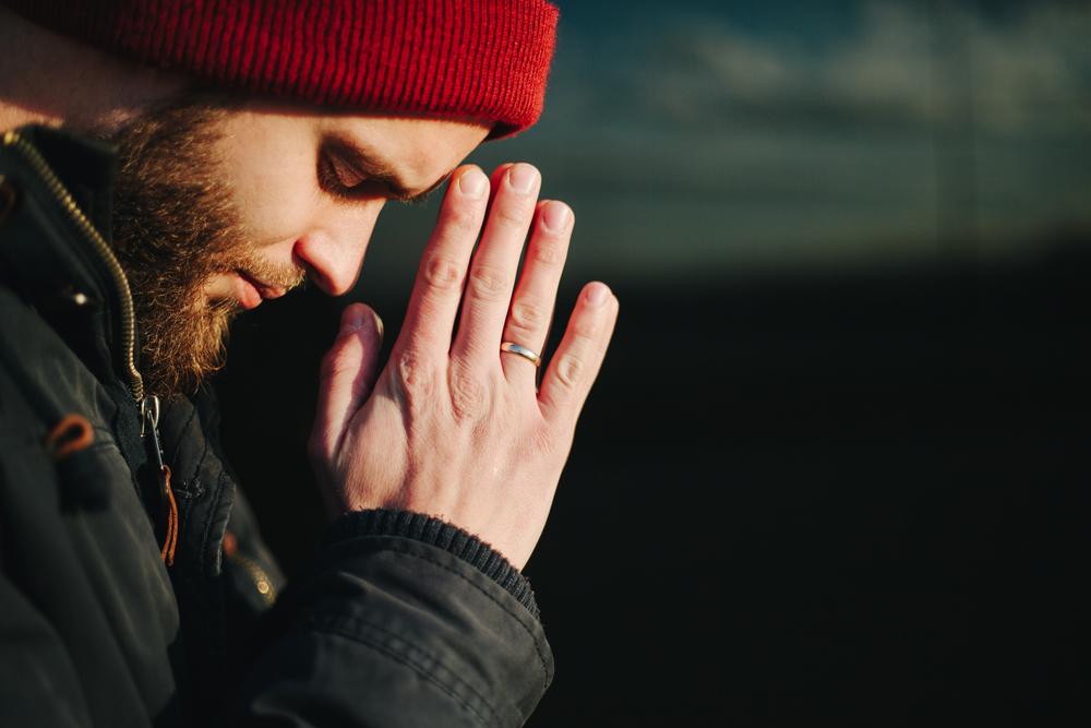 man praying in faith based addiction treatment program