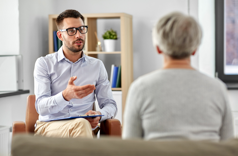 male therapist discussing mental health with senior woman