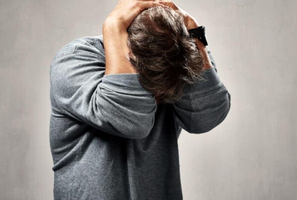 frusterated man holding his head