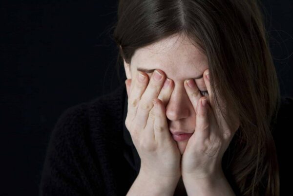 woman placing her hands over her face