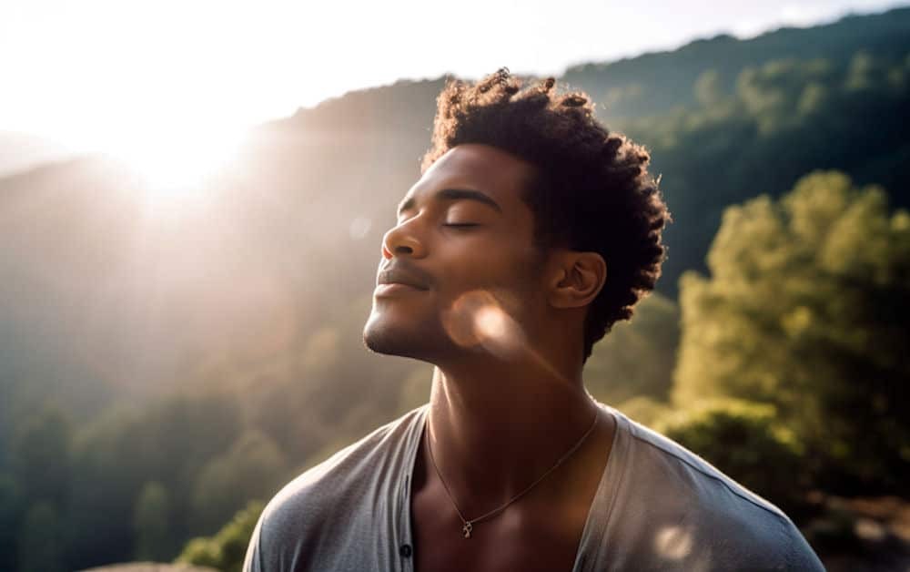 a man with head up closed eyes while enjoying sunshine