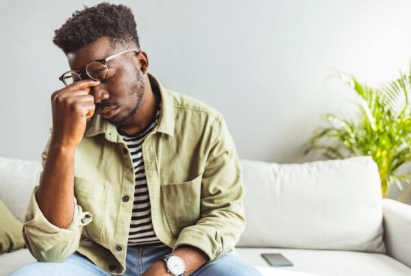 man pinching the bridge of his nose feeling stressed