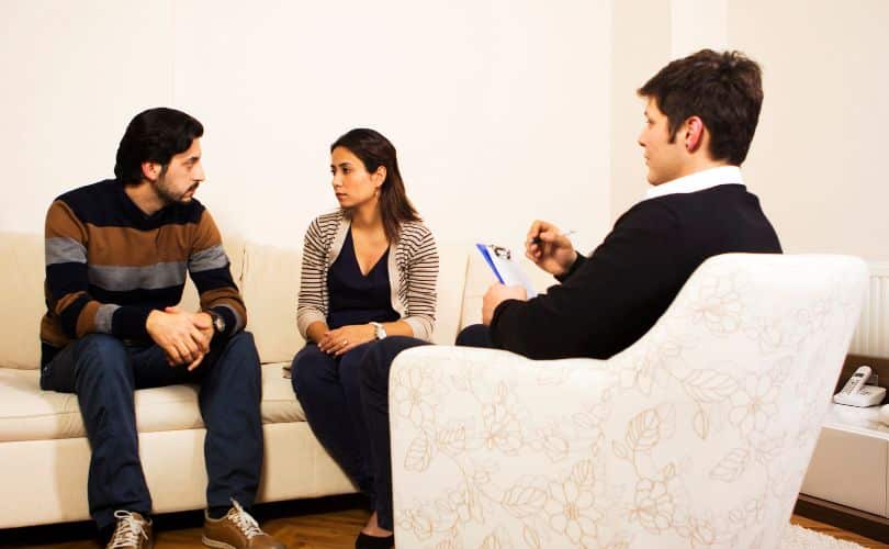 People sitting on a couch and chair during a counseling session.